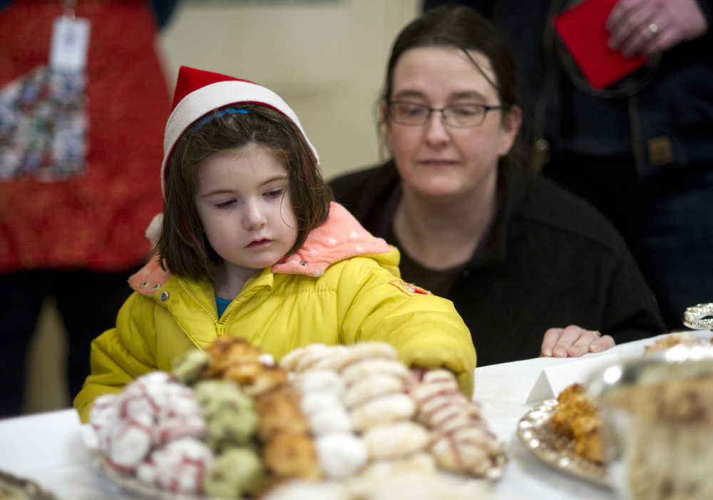 Lauren Sill watches has her daughter, Maggie, 4, select a cookie at the Governor's Open House on Tuesday.