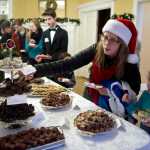Anna Blackwell reaches for some chocolate candy for her daughter, Naomi, 6, during the Governor's Open House on Tuesday.