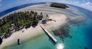 FILE - In this Nov. 8, 2015 aerial file photo , a small section of the atoll that has slipped beneath the water line only showing a small pile of rocks at low tide on Majuro Atoll in the Marshall Islands. They barely break the surface of the ocean but in the U.N. talks on how to stop rising seas and other hazards of a warming planet, small island nations have the moral high ground. While most countries think of climate change in terms of economic costs, Pacific atolls and remote island groups in the Indian Ocean and Caribbean picture a world map without them on it. Rising seas are already eroding their coast lines and contaminating their freshwater wells. Many are in the path of typhoons and hurricanes that scientists say could become more powerful as the climate warms.  (AP Photo/Rob Griffith, File)