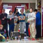 Gavin Gende celebrates his dragsters run during teacher Alan Denerger's technology class at Floyd Dryden Middle School on Thursday. The wooden cars are powered by a CO2 cartridge and race up to 60mph along a fishing line in the hallway.