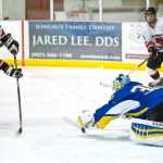 Monroe Catholic's goalie Nathaniel Jankowski, right, stops a point-blank shot from Juneau-Douglas'  Ryan Liebelt at Treadwell Arena on Saturday. Monroe Catholic won 3-1.
