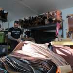 Dan Ewing in his shop and studio, a storage unit in Lemon Creek. In the foreground are some strips of leather he's cut for custom-made belts.