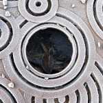Frosty grate harboring a nest of frosty leaves on Main Street.