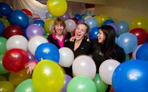 Rosanne Schmitz wades through nearly 2600 balloons with her daughter, Aileen, center, and friend, Tori Talley, right, in her livingroom on Monday. Schmitz tranformed her livingroom to celebrate her daughter's 21st birthday. Schmitz also opened her house to friends to frolic and ended it with a popping party Monday night.