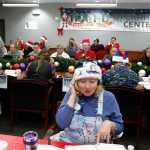 In this Dec. 24, 2014, file photo, volunteer Patty Shook takes a phone call from a child asking where Santa is and when he will deliver presents to her home, inside a phone-in center during the annual NORAD Tracks Santa Operation, at the North American Aerospace Defense Command, at Peterson Air Force Base, Colo. Patty and her husband, Bryan, who is retired from the Air Force, have been volunteering at NORAD each Christmas Eve for five years, fielding calls from children from all over the world eager to hear about Santa's progress.