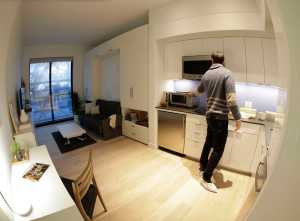 In this Dec. 22 photo, Stage 3 Properties co-founder Christopher Bledsoe talks about the kitchen appliances that come with one of the apartment units at the Carmel Place building in New York.