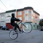 In this Nov. 9 photo, Shaun Britton does a trick on his bike as he crosses the street in the Bayview-Hunters Point district in San Francisco.