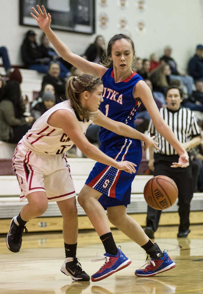 Juneau-Douglas' Erica Hurtte, left, passes around Sitka's Alexandra Kirby during the 2015 Princess Cruises Alaska Airlines Capital City Classic at JDHS on Monday. Juneau won 34-31.