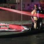 Firefighters stand near a piece of wreckage after a small plane slammed into a commercial building in downtown Anchorage early. Authorities say at least one person aboard died. Assistant Fire Chief Alex Boyd said there were no injuries on the ground.