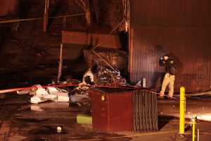 A National Transportation Safety Board investigator takes photos at the scene of an aircraft crash Tuesday in Anchorage.