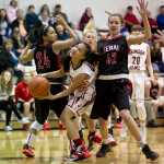 Juneau-Douglas' Alyxn Bohulano, center, looks for the basket between Kenai's Kelsey Booth, left, and Brooke Satathite during the Princess Cruises Alaska Airlines Capital City Classic at JDHS on Tuesday.