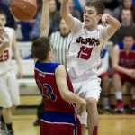 Juneau-Douglas' Kaleb Tompkins passes over Sitka's Tevin Bayne during the Princess Cruises Alaska Airlines Capital City Classic at JDHS on Tuesday. Juneau won 81-63.