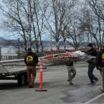 Workers load the remains of a small plane that crashed into two office building in downtown Anchorage onto a flatbed trailer on Tuesday.