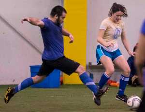Honey Badgers' Stefan Ashe, left, lunges for the ball posessed by Las Mamacitas y Los Yung Sahns' Monica Daugherty, right, during their masters division game in the Holiday Cup at the Dimond Park Fieldhouse on Wednesday. Las Mamacitas y Los Yung Sahns defeated the Honey Badgers 8-0.