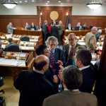 House Minority members cluster to talk as the House debates the state's operating budget at the Capitol on April 27, 2015.