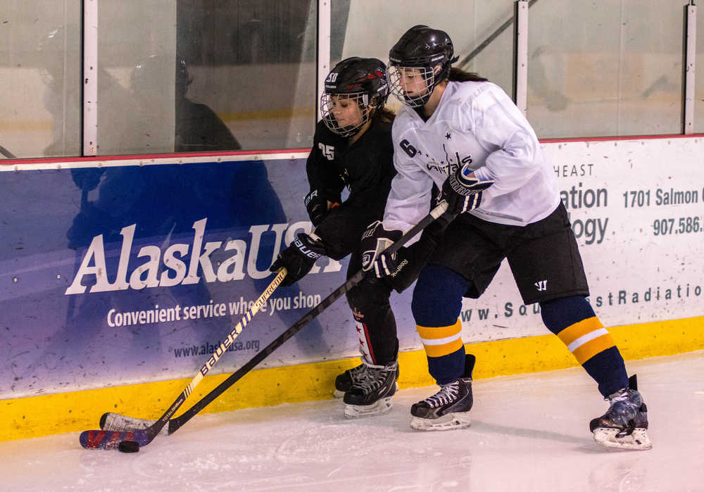 Jaime Hort, right, and Amelia Stopher battle for a puck along the boards during the Girls Only hockey session at Treadwell Arena.