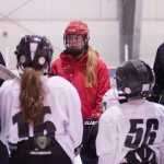 Junior Douglas Ice Association coach Mark Kaelke, left, talks to a group of youth skaters who attended his all-girls hockey session over the holiday break. He was joined by his daughter Emma (red helmet) and Juneau-Douglas High School assistant hockey coach Matt Boline, right.