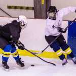 Kaylee Lanhum, left, covers Jaime Hort during a makeshift game during JDIA's all-girls hockey session at Treadwell Arena.