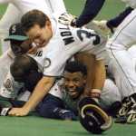In this Oct. 8, 1995 photo, Seattle Mariners' Ken Griffey Jr. smiles from beneath a pile of teammates who mobbed him after he scored the winning run in the bottom of the 11th inning against the New York Yankees.
