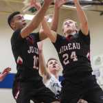 Juneau-Douglas' Molo Maka, left, and Erik Kelly block out Thunder Mountain's Luke Clark for a rebound at TMHS on Friday. JDHS won 66-47.
