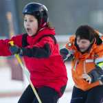 Jeorghette Plang, left, reacts to ski instructor Leslie Antolick's helpful push during the the World's Largest Lesson at Eaglecrest on Friday as part of Learn to Ski and Snowboard Month. The event, that included 80 participants and 17 instructors, was part of a national attempt to break a Guinness World Record.