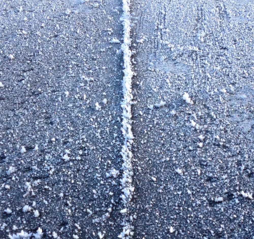 A frosty driveway ressembles a road through South Dakota in the winter time.