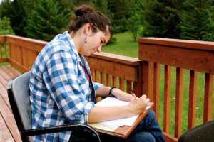 Megan Bush works on her writing during a previous Woosh Kinaadeiyí workshop.