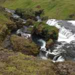 Hikers approach one of Icelands many waterfalls.