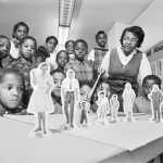 ADVANCE FOR USE MONDAY, JAN. 18, 2015 AND THEREAFTER - In this Nov. 15, 1967 file photo, teacher Clara Jones uses small figures to represent a family and interpersonal relationships during a class to help understand the complex emotional and physical problems of their growth, at Bancroft School in Washington. According to the National Conference of State Legislatures, 22 states and the District of Columbia require public schools to teach sex education in 2016. (AP Photo)