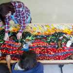 Artist Marianne Manning, lower left, works with Dzantik'i Heeni Middle School students on a three by eight-foot glass mosaic based on a painting by Dutch artist Vincent van Gogh on Wednesday. Manning is spending two weeks working with the middle school students on producing two glass mosaic panels as part of the Artist in the Schools Program.