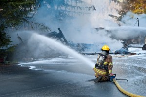 In this file photo from May 2015, a Capital City Fire/Rescue firefighter fights a North Douglas fire at a home and a garage.
