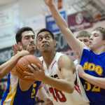 Juneau-Douglas's Molo Maka drive's against Kodiak's Louis Rochelan, right, and Ryan Bezena, left, during their game at JDHS on Friday. Juneau won 75-40.