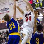 Juneau Douglas's Erik Kelly shoots against Kodiak's Louis Rochelan, left, and Billy Alcaide, right, during their game at JDHS on Friday. Juneau won 75-40.