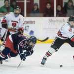 Juneau-Douglas' Ryan Leibelt, right, clears the puck away from North Pole's Dylan Latham in JDHS's final home game of the season on Friday.