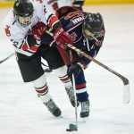 Juneau-Douglas' Kasey Watts, left, tangles with North Pole's Darren Donovan during JDHS's final home game of the season on Friday.