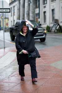 Shelly Wright holds her coat during a blast of wind and rain downtown on Thursday. The National Weather Service forecast for Friday calls for numerous rain showers, highs around 39. Southeast wind 10 mph.