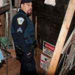 Sitka Police Sgt. Walter Smith stands in the entryway of a  tunneled space under a trailer in Vitskari Trailer Park in Sitka, Alaska, Thursday, January 28, 2016. A man wanted on criminal warrants was hiding under the trailer in what police called "an elaborate tunnel system." (AP Photo/Daily Sitka Sentinel, James Poulson)