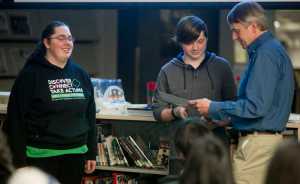 Jordan Cooper, left, and Brady Allio receive their first-place certificates in videography from Roger Healy for the Jan Neimeyer iDida Photography and Video Contest at Thunder Mountain High School on Thursday. Healy is the husband of Neimeyer, a local art teacher who died in August 2013.