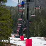 A skier rides the Hooter Chairlift over uncovered ground at the Eaglecrest Ski Area on Monday.