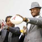 Gordo High School football player Ben Davis, with his mother Faye, left, holds up a football after committing to attend Alabama during a national signing day program at Gordo High School on Wednesday in Tuscaloosa, Alabama.