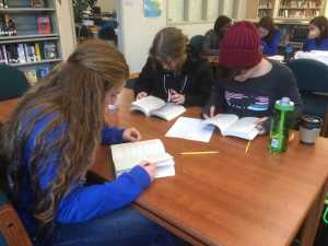 Audrey Welling, Lillian Bannerman and Sierra Brooks (front) and Freddie George, Ava Tompkins and Morgan Rivest (rear) search for passages in books for a question challenge during the Thunder Mountain High School Battle of the Books Competition which took place on Feb. 2.