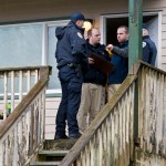 Juneau Police Department detectives and officers are shown at the front door of a first floor unit at the Admiralty Condos in the 2700 block of Roger Street in Douglas on Sunday. JPD confirmed two bodies were discovered after receiving a 911 call Sunday afternoon