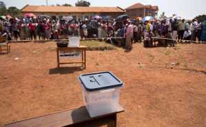 Voters queue at a polling station where a ballot box sits empty Thursday in the capital Kampala, Uganda. Five hours after voting was due to start no voting papers had yet arrived.
