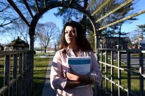 In this Feb. 2, 2016 photo, Naila Amin, 26, holds a book from one of the classes she is taking at Nassau Community College in Garden City, N.Y. Amin, who was forced into marriage at the age of 15 to a 28-year-old cousin in Pakistan who beat and mistreated her, aspires to become a social worker and open a group home for girls trying to avoid or recover from forced marriages. (AP Photo/Kathy Kmonicek)