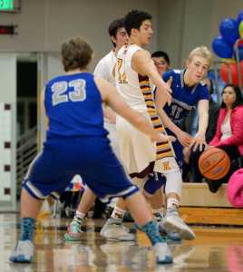 Thunder Mountain junior Chase Saviers (11, blue jersey) passes the ball around Ketchikan High School senior Jason James (11, white jersey) to junior Riley Olsen (23) on Friday, Feb. 19, 2016, during the Falcons' 54-62 loss to the Kings in the Clarke Cochrane Gym.