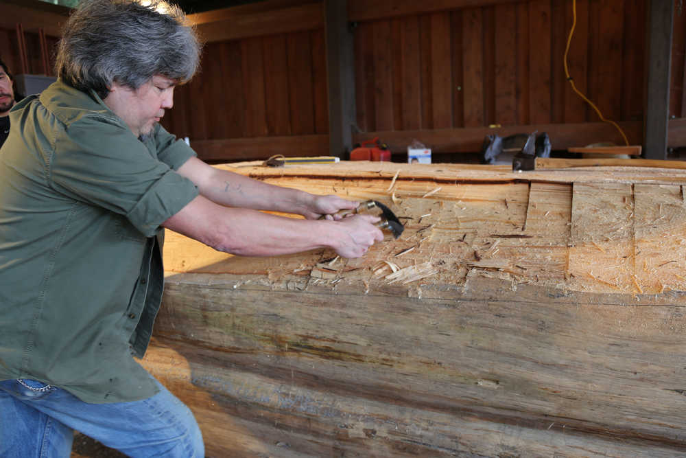 Sitka carver Tommy Joseph works on the beginnings of a canoe at Sitka National Historical Park, a project led by master carver Steve Brown. (National Park Service | Erin Fulton)