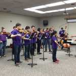 Students practice violin with Go Hua Xia instructing.