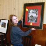 Nelli Wayne, 17, puts one of her paintings up at The Rookery. Nelli, mother Kathleen Wayne, and Anna Wayne, 14, have a family show at The Rookery that kicks off this Friday. The exhibit is called "At the Art of It."