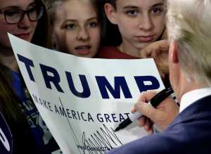 Republican presidential candidate Donald Trump autographs for supporters during a rally at Wexford County Civic Center, Friday, March 4, 2016, in Cadillac, Mich. (AP Photo/Nam Y. Huh)
