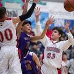 Hydaburg's Michal Eaglestaff, center, passes the ball away from Klawock's Nate Yockey, left, and Blaine Dilts in the 1A Region V Basketball Championship game at Thunder Mountain High School on Friday. Hydaburg won 34-29.